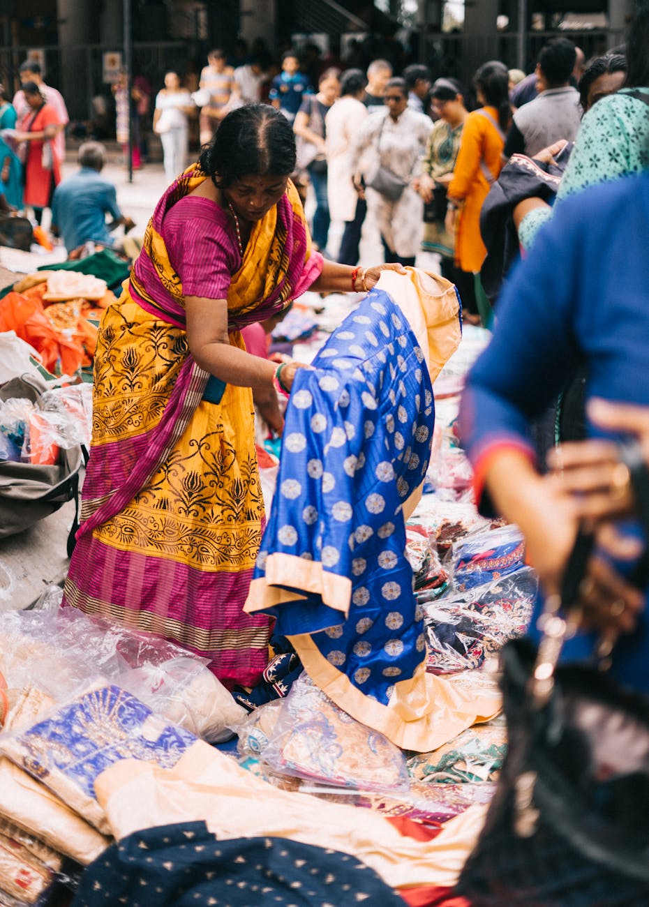 woman holding blue and white indian traditional dress near people